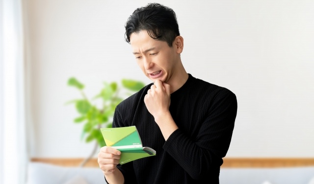 通帳を見る男性